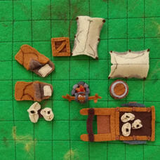 Assorted tokens of camping equipment in a circle on a gridded background.